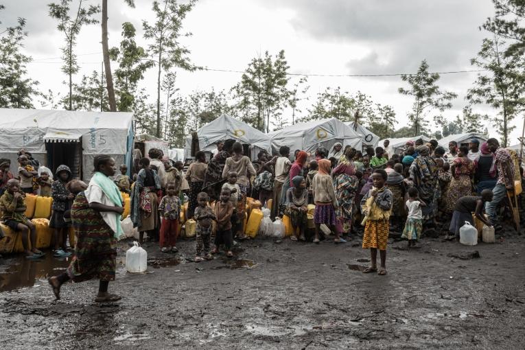 Des personnes déplacées du camp de Rusayo font la queue pour collecter de l'eau. 