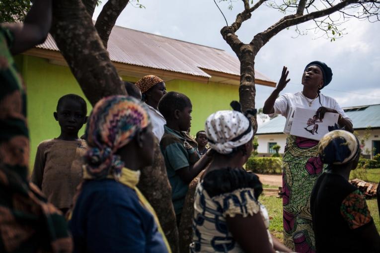 En marge des activités de décontamination d'un hôpital, une travailleuse de santé MSF sensibilise les personnes présentes à l'importance du dépistage Ebola. Novembre 2018. République démocratique du Congo.
 © Alexis Huguet