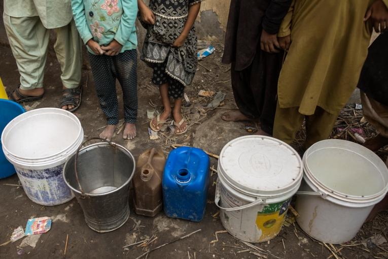 Des enfants se tiennent en rang avec leur seau pour le remplir d'eau dans un camp où les familles touchées par les inondations se sont réfugiées dans la province de Sukkur au Pakistan le 28 octobre 2022.
 © Asim Hafeez