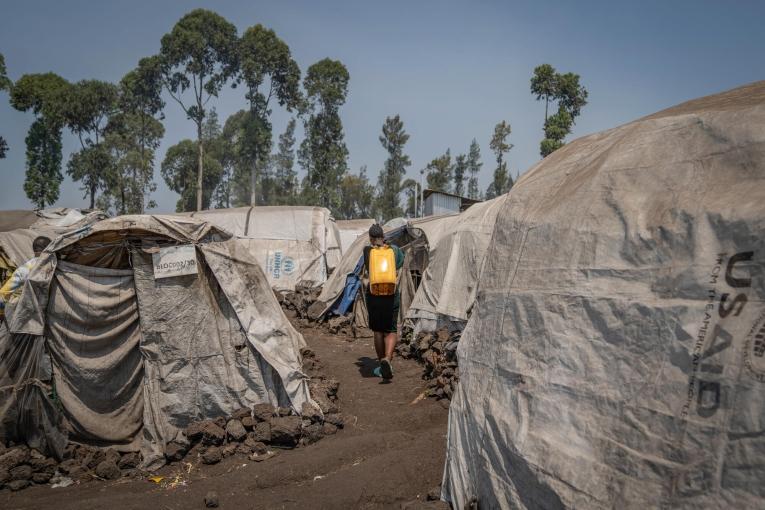 Rebecca ramène de l'eau chez elle, en marchant entre les tentes du camp d'Elohim.