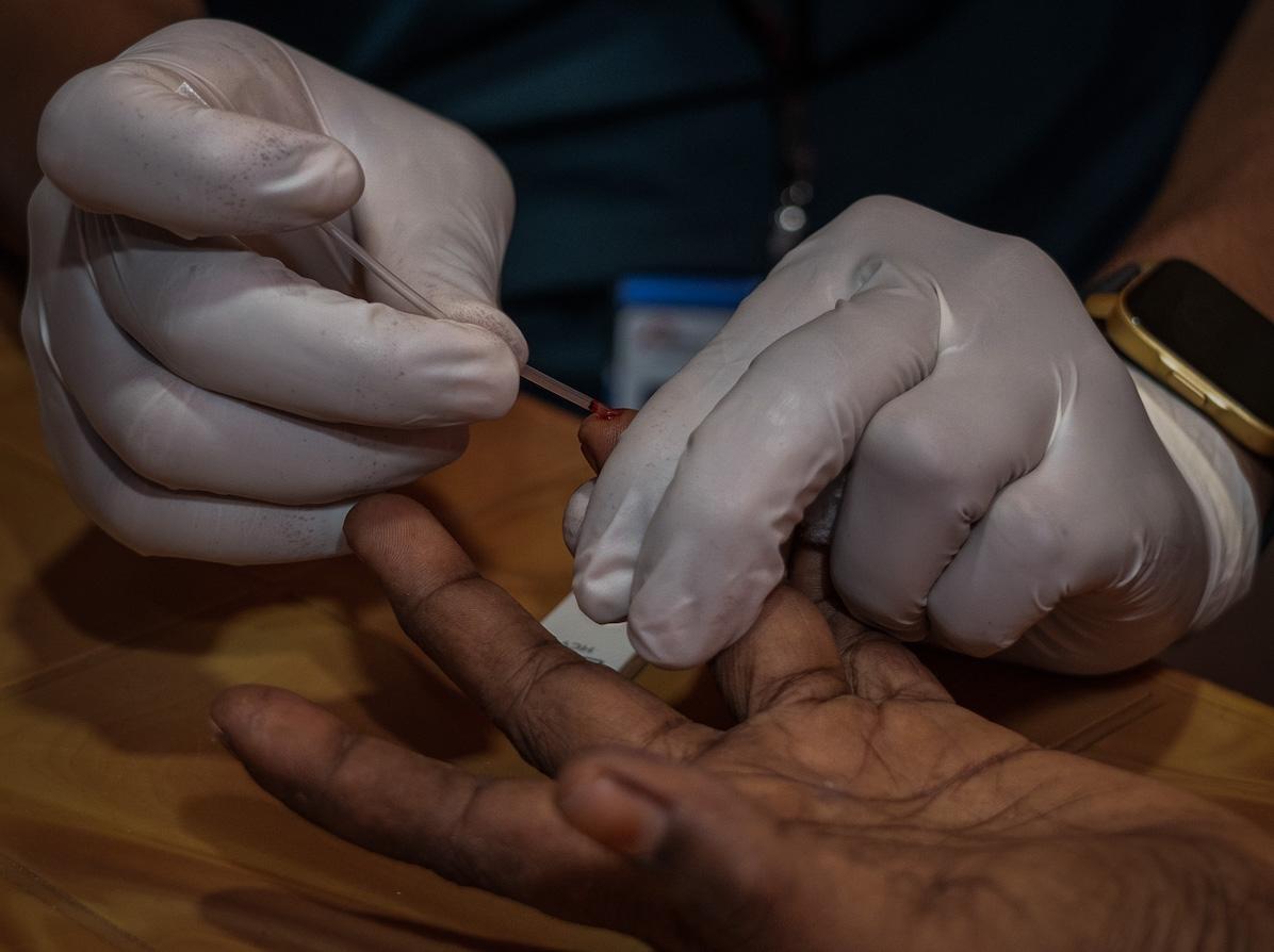 Un membre de l’équipe MSF prélève un échantillon de sang sur un patient pour effectuer un test diagnostic rapide (TDR) de l'hépatite C dans la salle de consultation de l'hôpital MSF, à Cox's Bazar, Bangladesh.