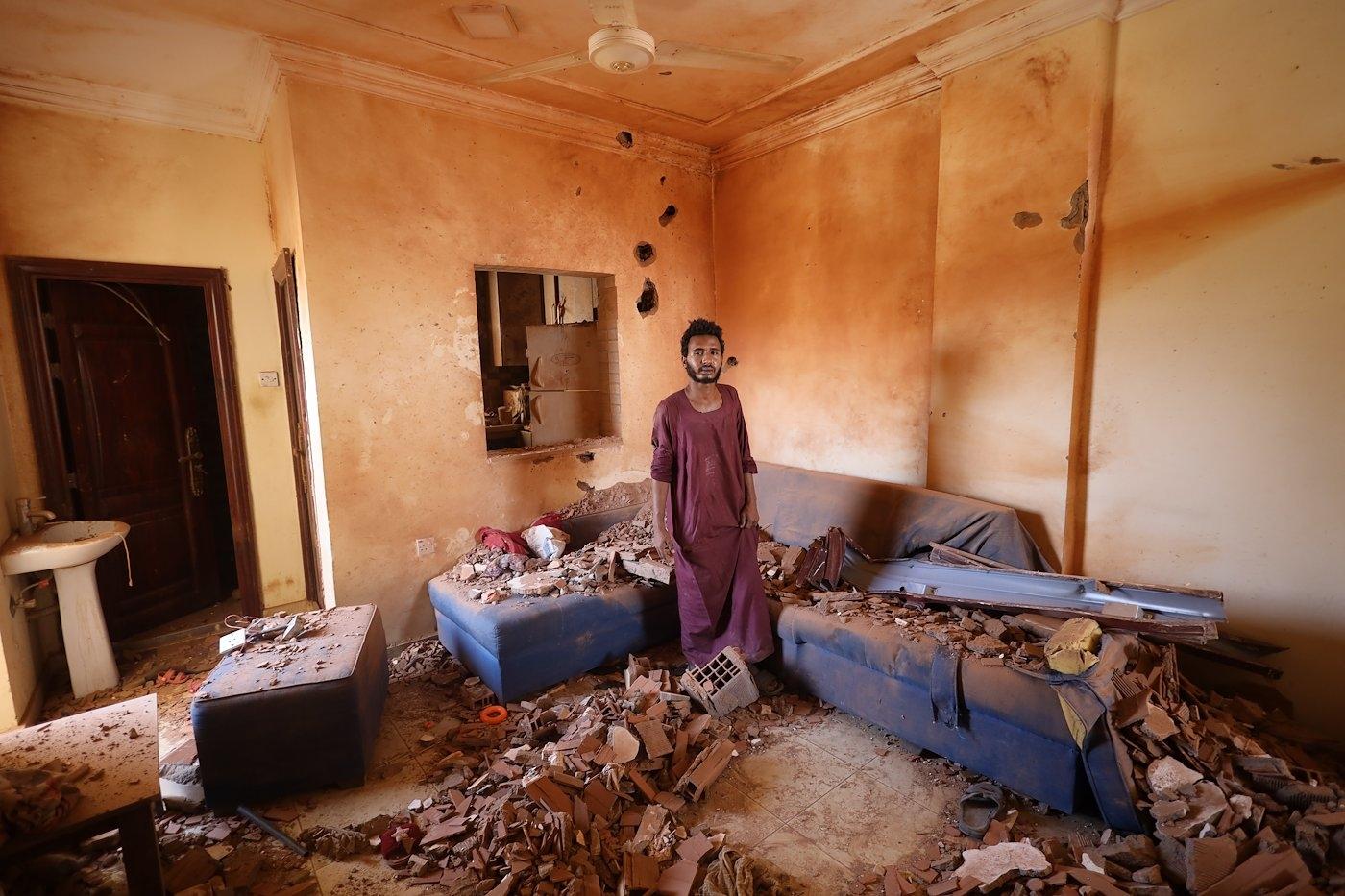 Un homme debout dans sa maison détruite