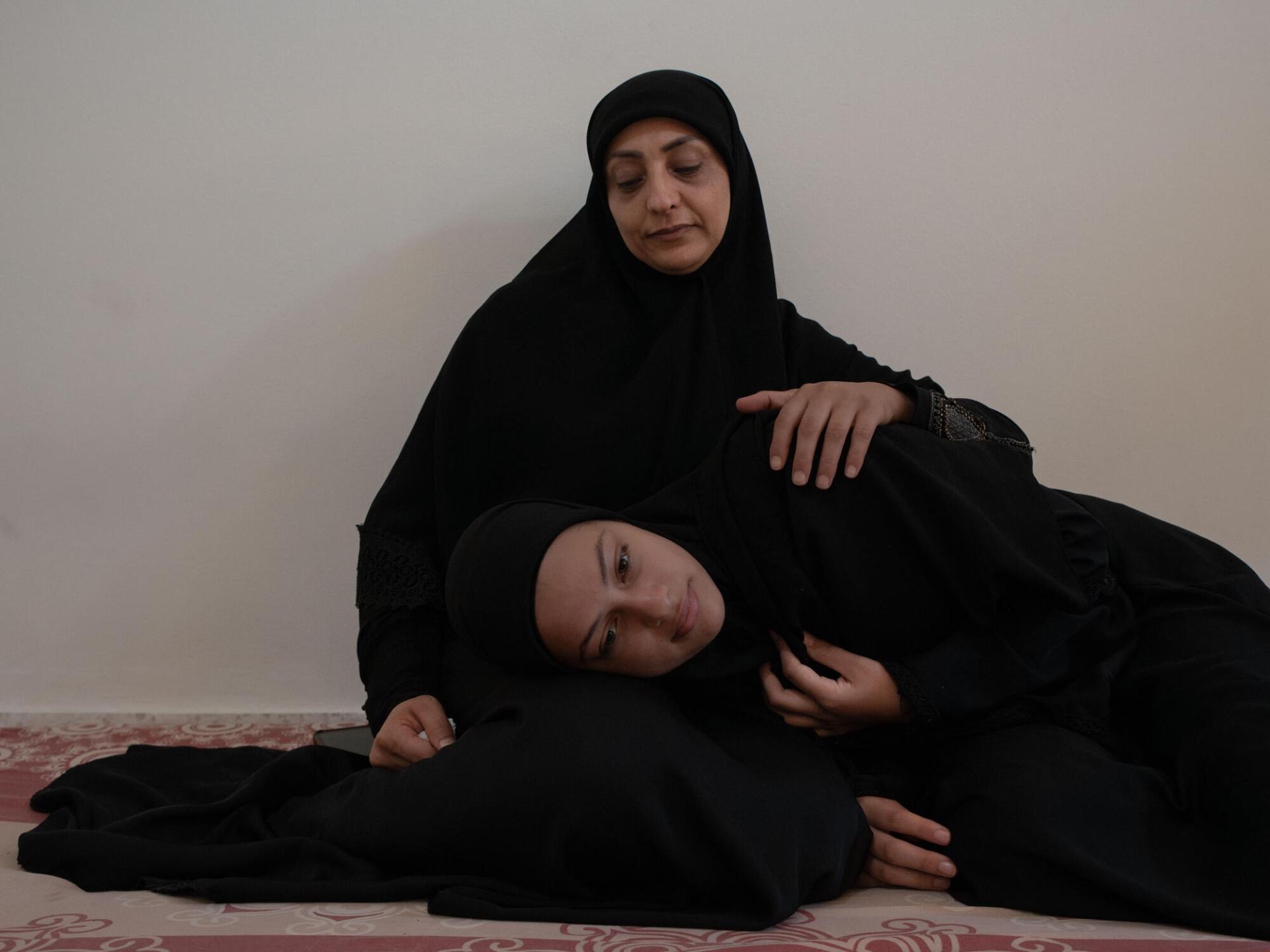 Ezdihar al Diqa, 39 ans, et sa fille Nouraya, 14 ans, dans la chambre qu’elles partagent depuis le 29 septembre avec 14 autres personnes dans l'abri d'Azarieh dans le centre de la capitale libanaise. Octobre 2024.