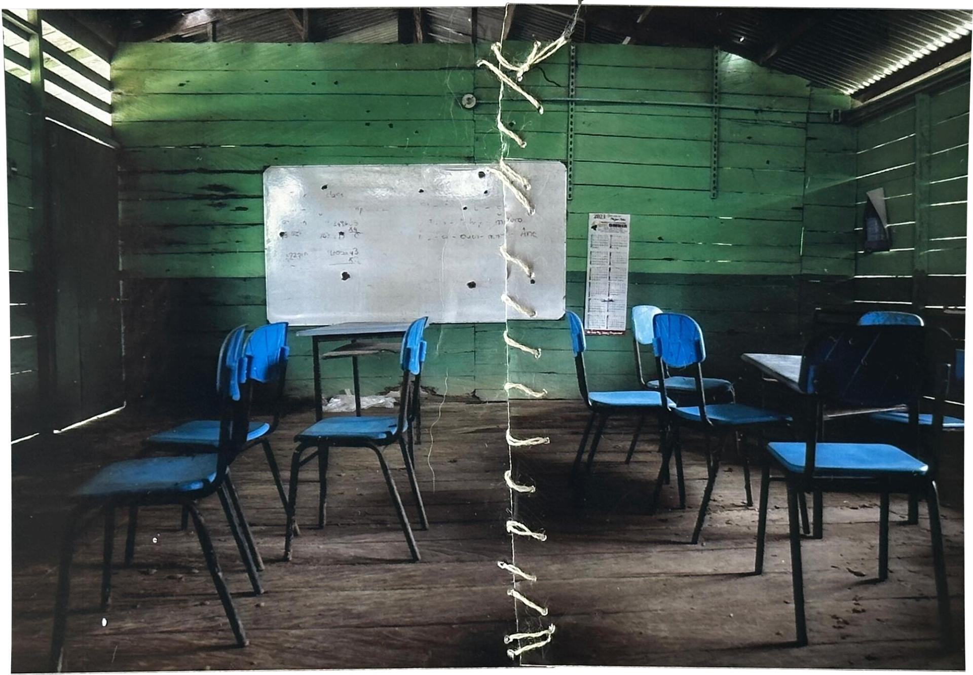 Margarita Rojas Mena, guérisseuse traditionnelle du village de Mojaudó, a recousu une photographie d'une école touchée par l'attaque d'un groupe armé.