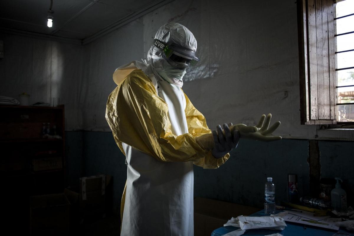 Un travailleur de santé MSF revêt son équipement de protection personnel avant d'entrer dans la zone à risque du centre d'isolement Ebola de Bunia. Il va procéder à une évaluation de l'état des patients. Novembre 2018. République démocratique du Congo.
 © John Wessels