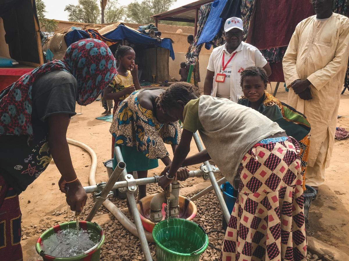 Sur le deuxième site, à l'intérieur de l'école maternelle, des jeunes filles vont chercher de l'eau à une borne-fontaine rétablie par MSF à l'arrivée des déplacés.
 © Aichata Diakité/MSF