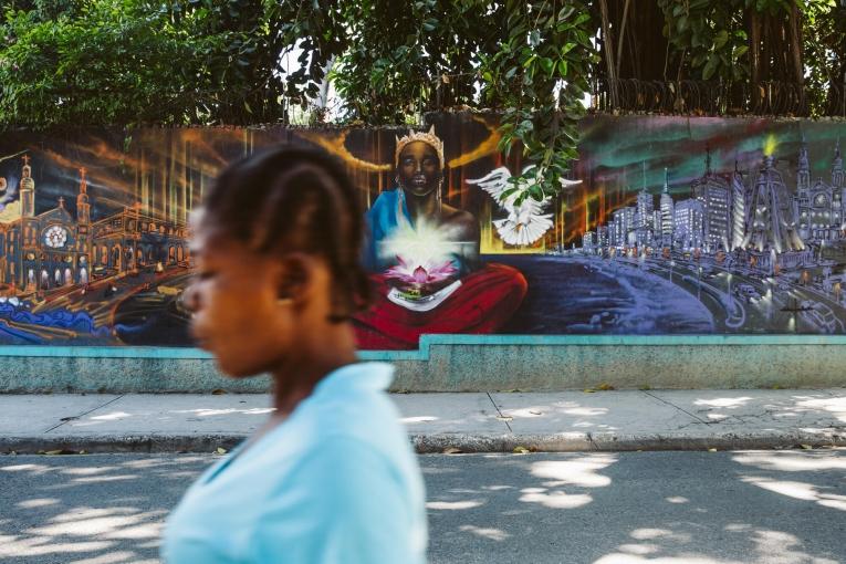 Une passante devant une fresque dans un quartier résidentiel de Port-au-Prince.
 © Valerie Baeriswyl