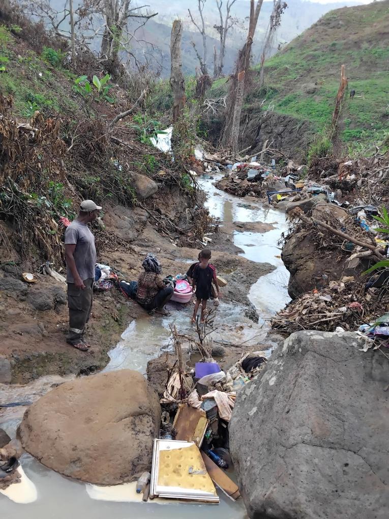 Les gens lavent leurs vêtements dans l'eau sale de la rivière, remplie de déchets, dans le bidonville de Vahibé, où MSF mène une clinique mobile.
 © Thierry Arhan/MSF