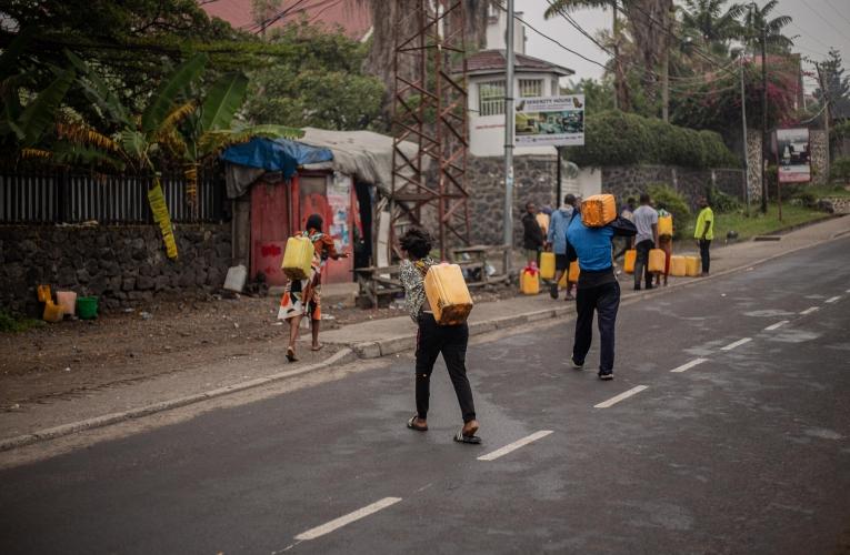 Des habitants de Goma transportent des jerrycans d'eau potable alors que la ville est soumise à des interruptions du service d'eau.
 © Jospin Mwisha