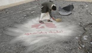 Un homme balaye des débris du bombardement du 26 octobre sur l’hôpital de Haydan révélant le logo MSF peint sur le toit de l'hôpital.