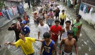 Victimes des inondations se dirigeant vers un centre d’évacuation à Pateros à l’est de Manille.