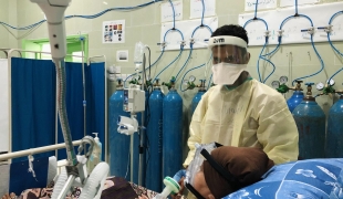 Un membre du personnel médical s'occupe d'un patient dans l'unité de soins intensifs de l'hôpital Al Gamhouria à Aden, mars 2021. 