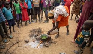 Une femme cuisine des feuilles d'arbres pour tenter de subvenir aux besoins de ses cinq enfants. Soudan du Sud. 2022.