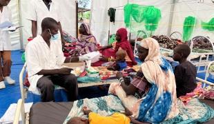 Un membre des équipes MSF avec une mère et son enfant dans l'hôpital d'Adré au Tchad. 2023.