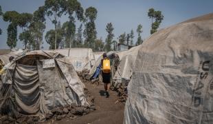 Rebecca ramène de l'eau chez elle, en marchant entre les tentes du camp d'Elohim.