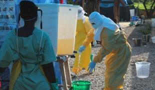 Procédure de désinfection d'un personnel MSF après avoir travaillé dans la zone à haut risque dans le centre de prise en charge d'Ebola à Foya au Liberia. Martin Zinggl/MSF