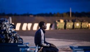 Un jeune homme en provenance de Gambie prie dans le camp de transit de Augusta en Italie quelqeus heures après avoir été repêché en mer. Septembre 2014.