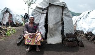 Comme Victorine cette femme déplacée se tient devant son abri dans le camp de Bulengo