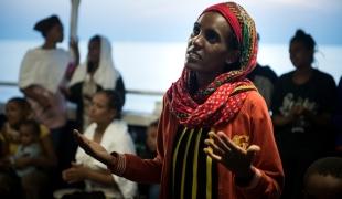 Une femme érythréenne chante une prière avec d'autres femmes et enfants après avoir été secourue le 2 septembre 2015 en mer Méditerranée par le MY Phoenix bateau de recherche et de sauvetage de MSF.