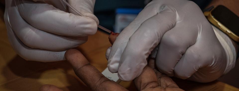 Un membre de l’équipe MSF prélève un échantillon de sang sur un patient pour effectuer un test diagnostic rapide (TDR) de l'hépatite C dans la salle de consultation de l'hôpital MSF, à Cox's Bazar, Bangladesh.