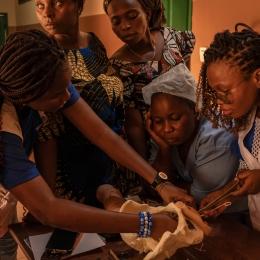 Victoire Irène Sossou, 26 ans, sage-femme avec MSF (debout à droite) forme d’autres sages-femmes et aides-soignantes d'Etat au centre de santé de Toviklin, Benin, le 16 janvier 2025. ©Adrienne Surprenant / MYOP