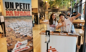 Deux recruteurs de donateurs sont derrière leur stand dans une galerie commerçante